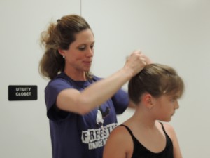 Ballet teacher Mrs. Kristen helps a student during the Freestyle Dance Academy showcase.